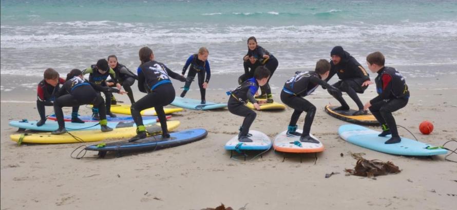 Des surfeurs de Plouider attentifs aux bons conseils d’Anthony sur la plage de Boutrouilles. - Crédit: Ouest-France